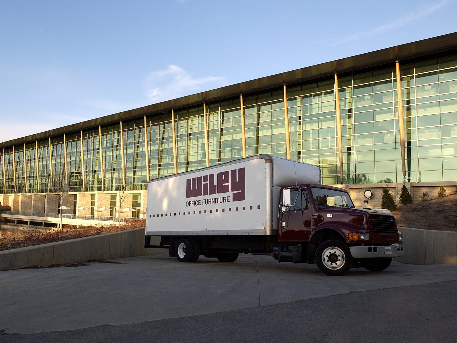 glass building with maroon Wiley Office delivery truck