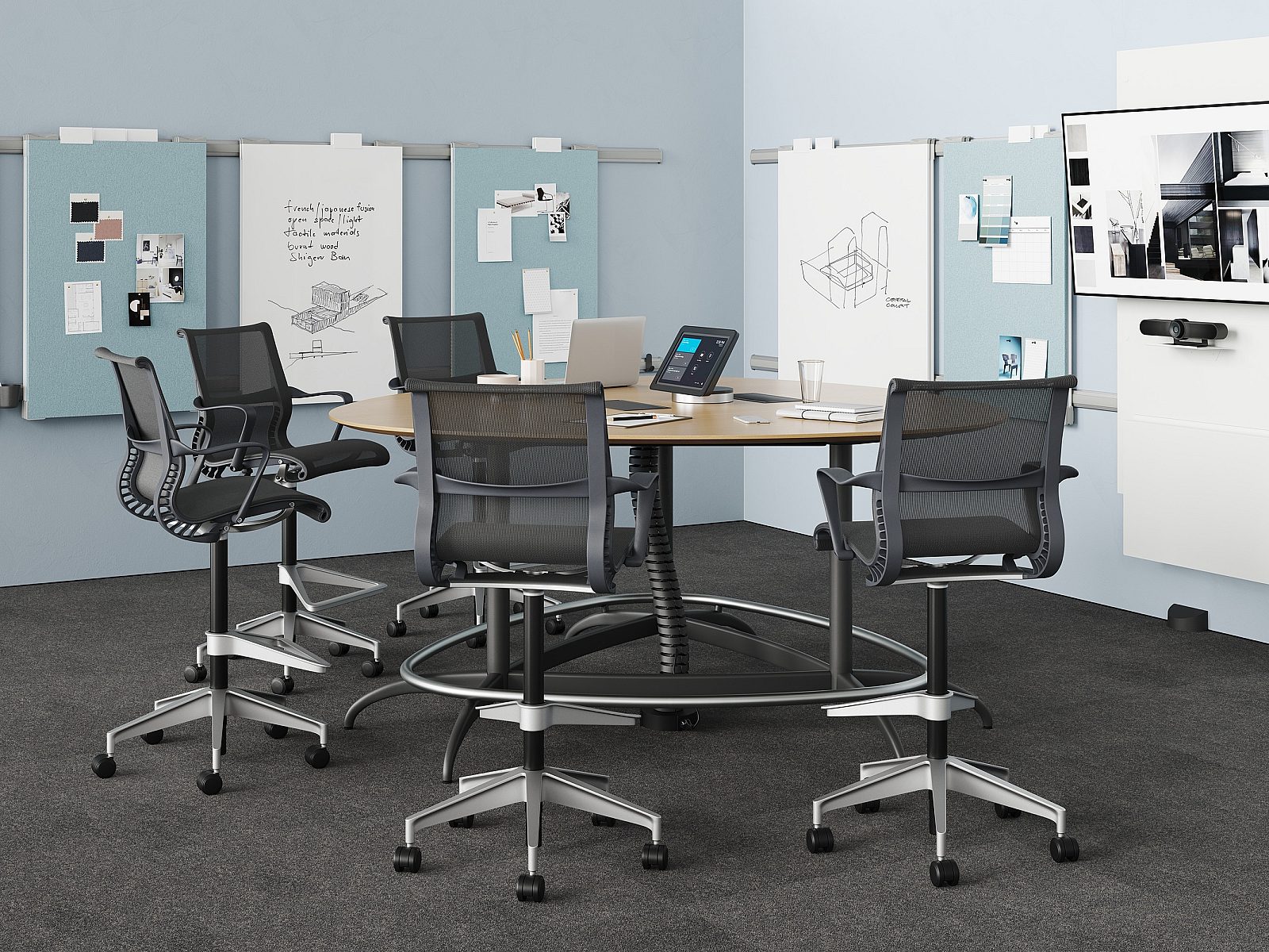 Exclave standing height conference with graphite Setu stools on gray carpet with blue tack boards and white boards on blue walls