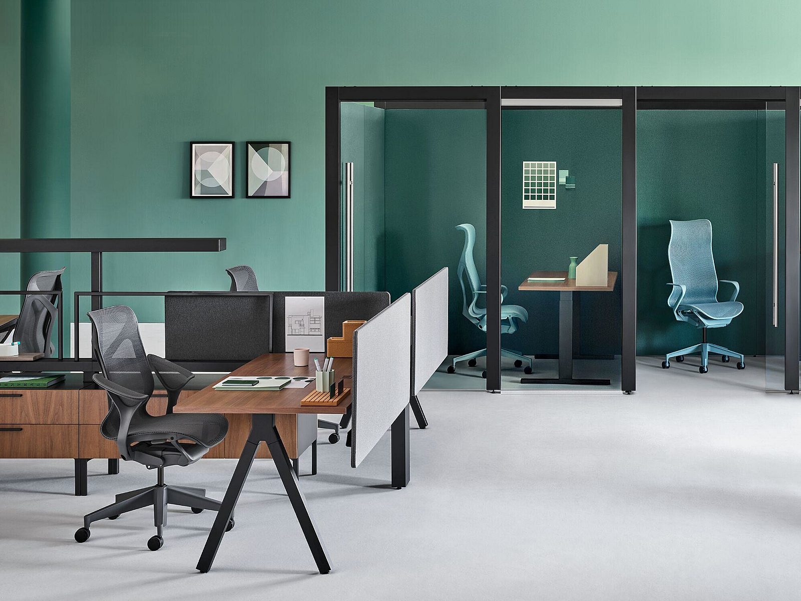 Open workstations in front of Glass privacy stations with bold green wall paint.