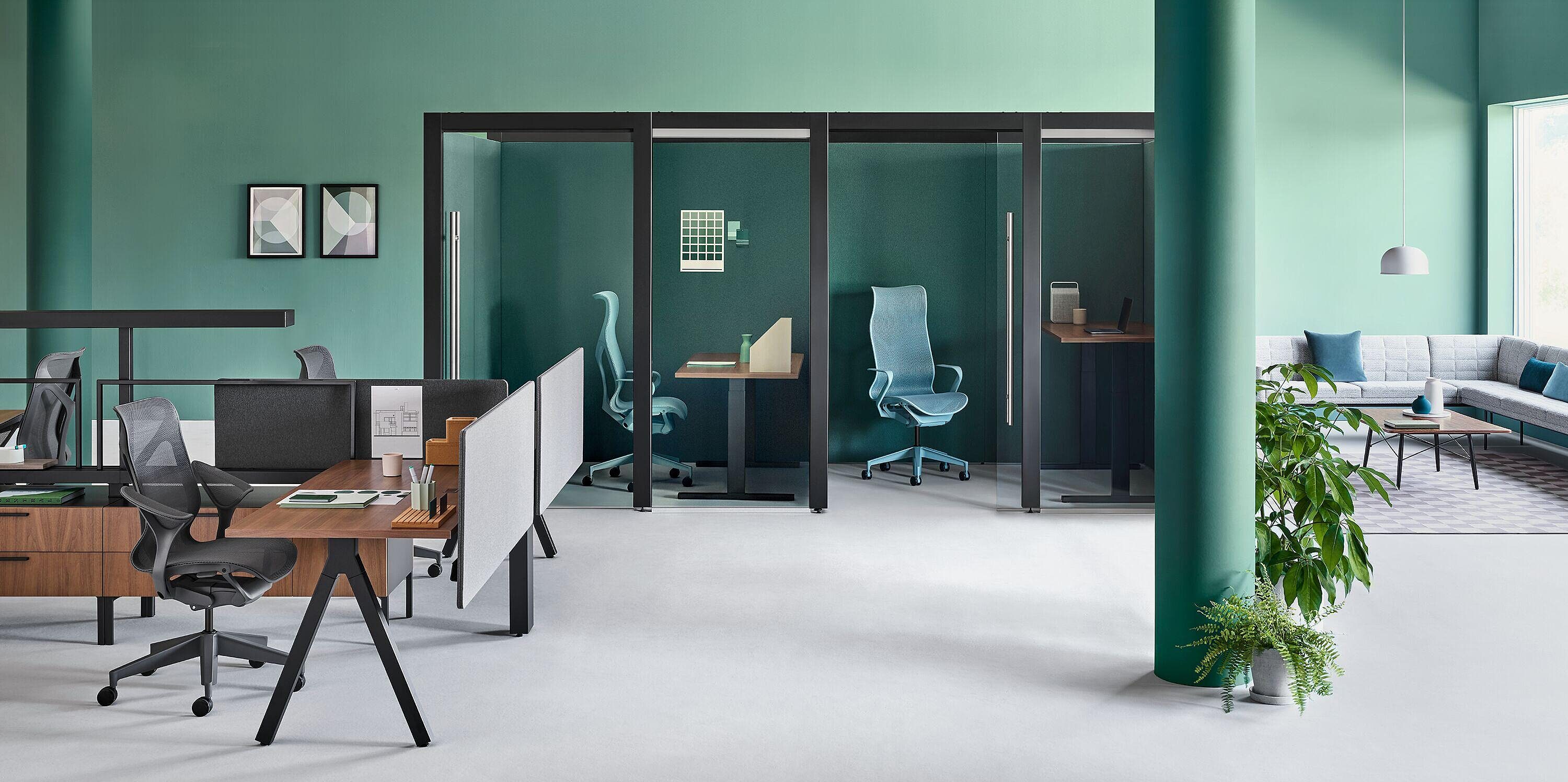 Open workstations in front of Glass privacy stations with bold green wall paint.