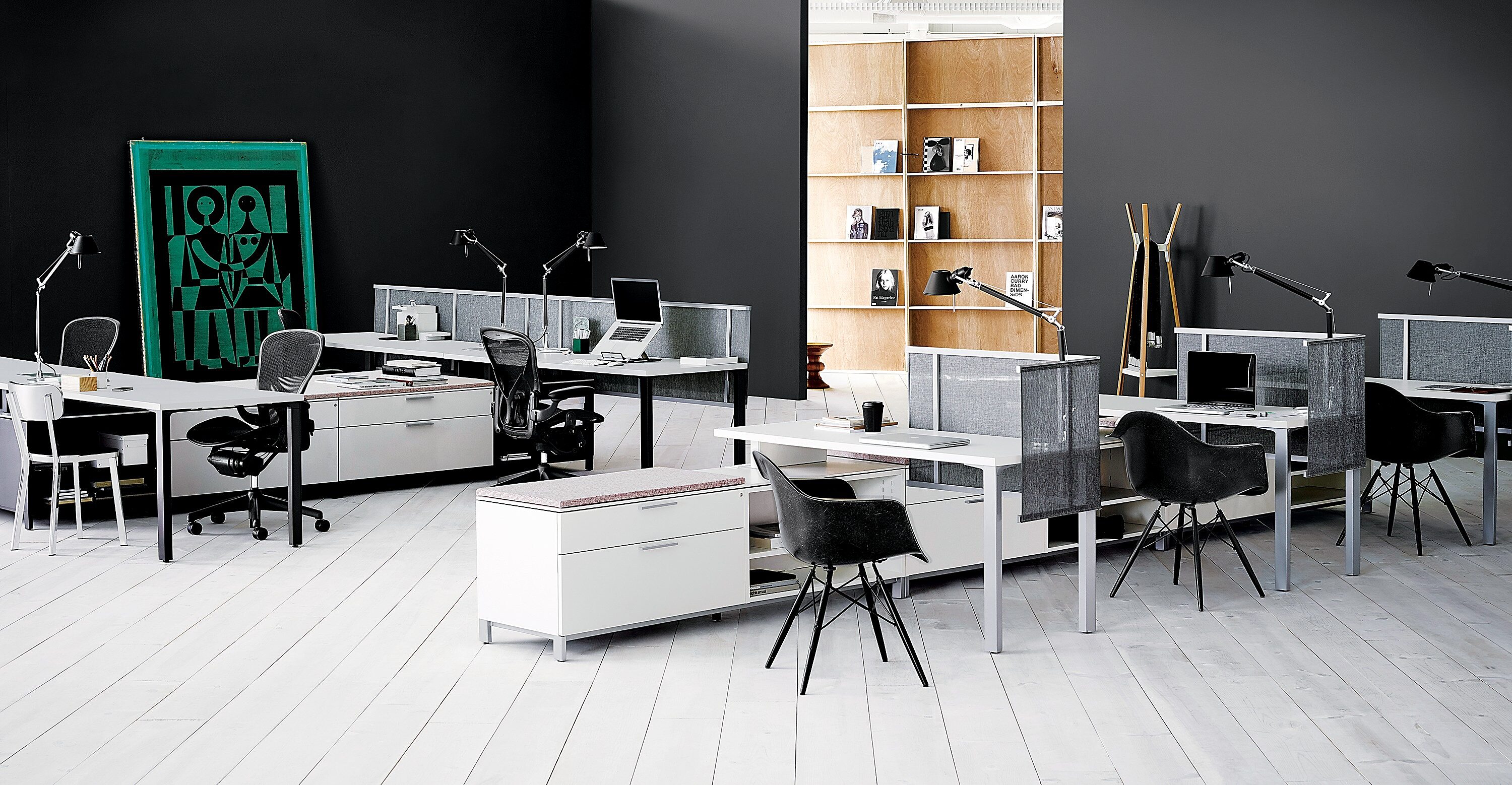 white workstations with black seating and tall black walls