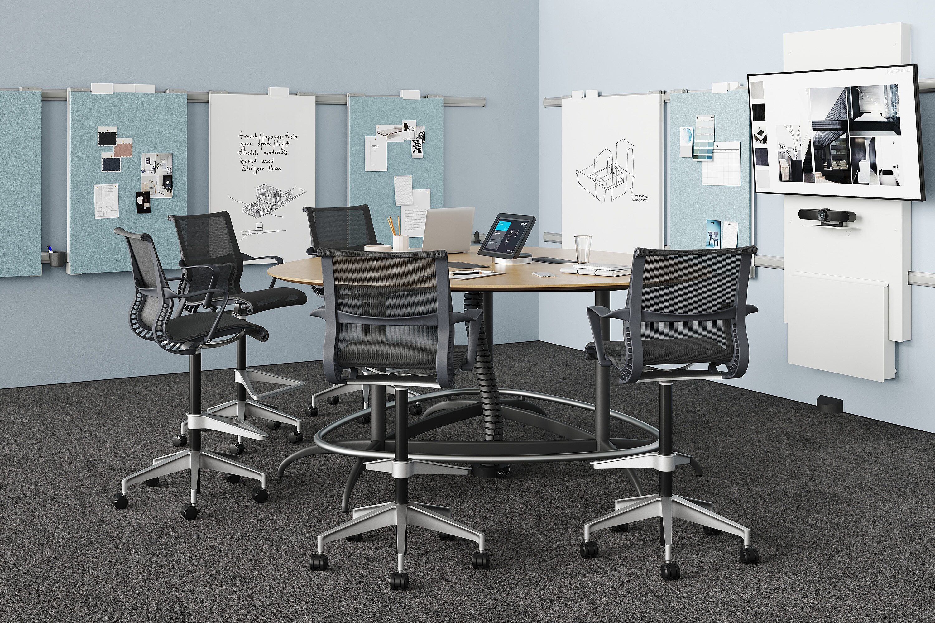 Exclave standing height conference with graphite Setu stools on gray carpet with blue tack boards and white boards on blue walls