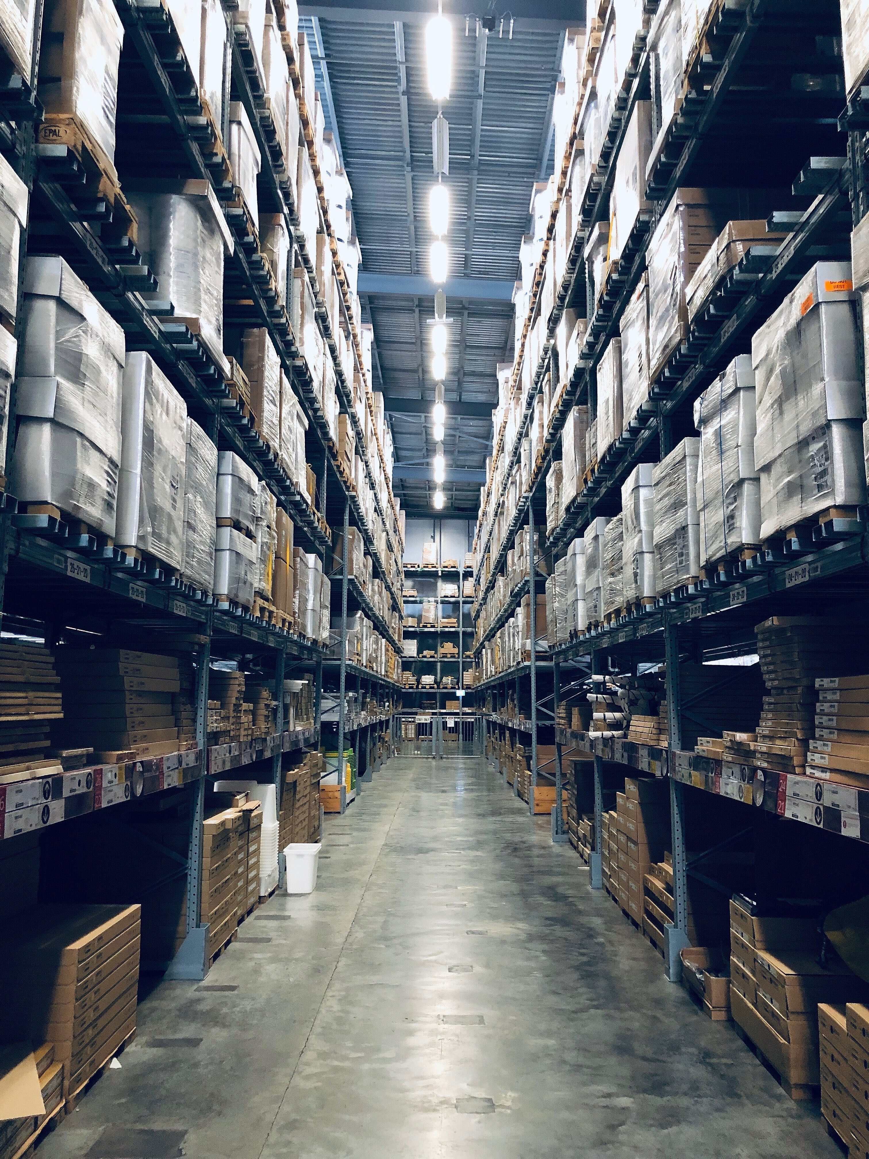 warehouse aisle with shelving full of pallets