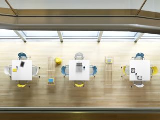 aerial view of white square tables with white, blue, and yellow seating on ash flooring