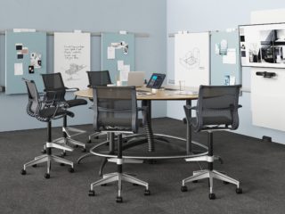Exclave standing height conference with graphite Setu stools on gray carpet with blue tack boards and white boards on blue walls